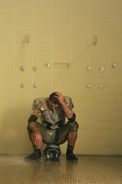 Dejected Football Player Sitting in the Showers